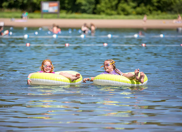 istock Two Girls Floating on Inner Tubes At Swimming Beach 543984856