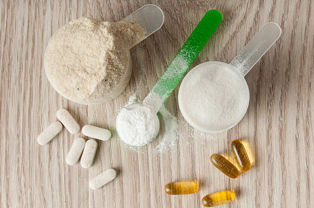 scoop of protein, bcaa and creatine, omega3 in pills scoop of protein, bcaa and creatine, omega3 in pills on wooden background food additive stock pictures, royalty-free photos & images