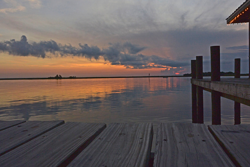 Summer storms bring in clouds as the sun crosses the horizon. 