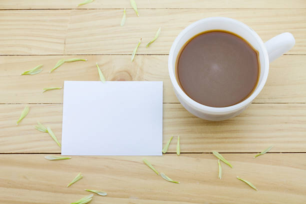 istock Coffee mug with White on yellow rustic table.flower petals 543987810