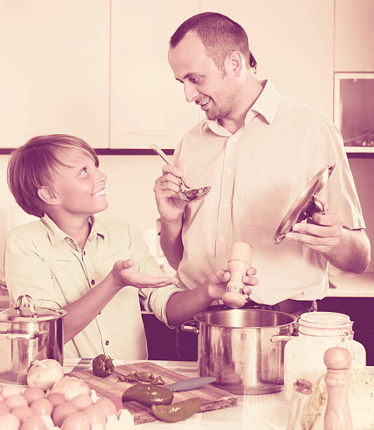 istock Father and teenage son cooking together 543994876