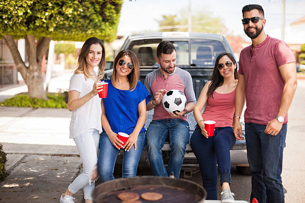 group of friends hanging out at a soccer game - fan football sport tailgate party imagens e fotografias de stock