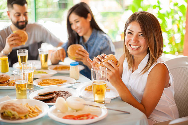 istock Cute brunette eating a burger with her friends 543997418