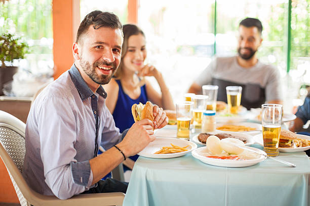 istock Handsome man eating hamburger with friends 543997714