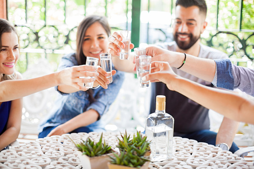 Grupo de amigos haciendo un brindis con tequila photo