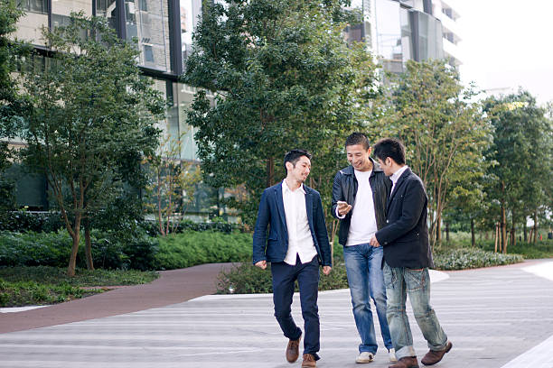 istock Three people are watching a smartphone on a sidewalk 544000674