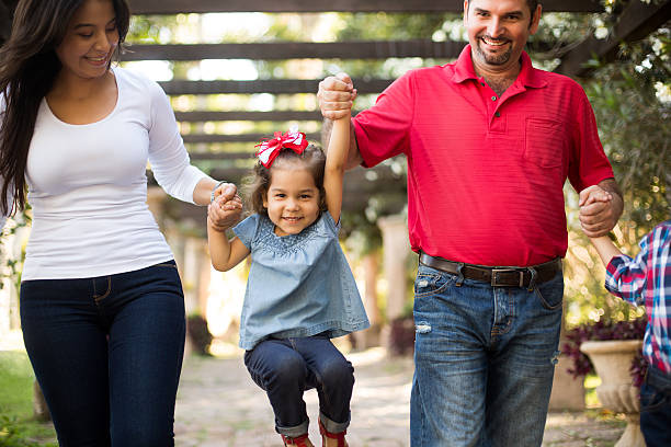 istock Young mother and father picking up little daughter 544002402
