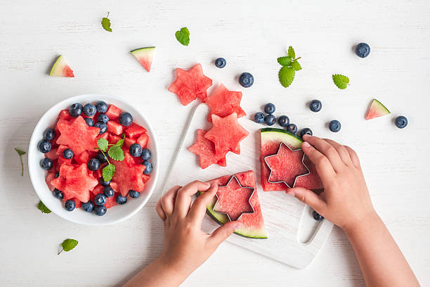 mains d’enfants cuisinant salade sur table blanche, plat - watermelon fruit healthy eating snack photos et images de collection