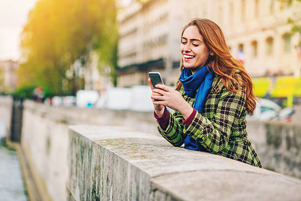 jovem mulher com telefone inteligente no rio sena, em paris - seine net fotos - fotografias e filmes do acervo