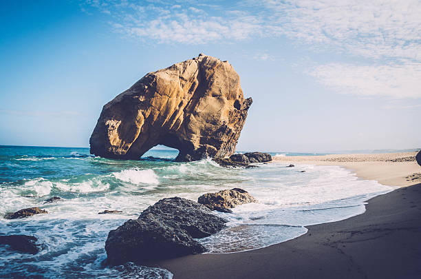 Penedo do Guincho - Santa Cruz Beach, near Lisbon, Portugal: towering rock 98 feet high and 328 feet in circumference with a crack at its base.