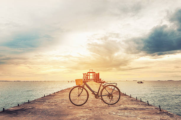 istock Vintage bicycle on concrete pier in sunset, vintage tone 544106434