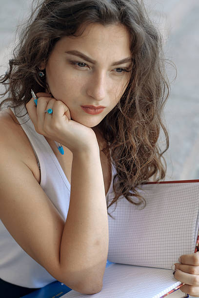 istock Girl with books sitting on the steps 544110442