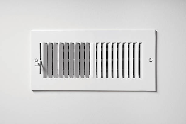 Heating/Cooling Vent A heating/cooling vent register on the wall of a home, with open/close lever latch photos stock pictures, royalty-free photos & images