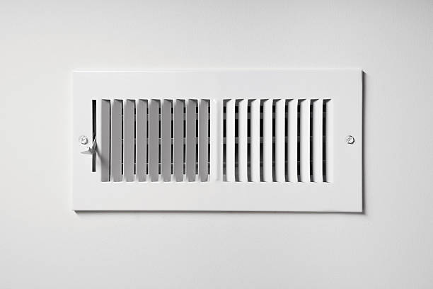 Heating/Cooling Vent A heating/cooling vent register on the wall of a home, with open/close lever duct stock pictures, royalty-free photos & images