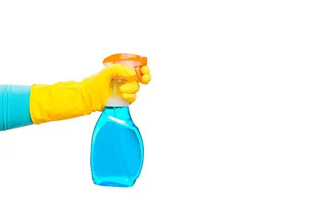 hand in yellow glove holding a spray for cleaning glasses on white background