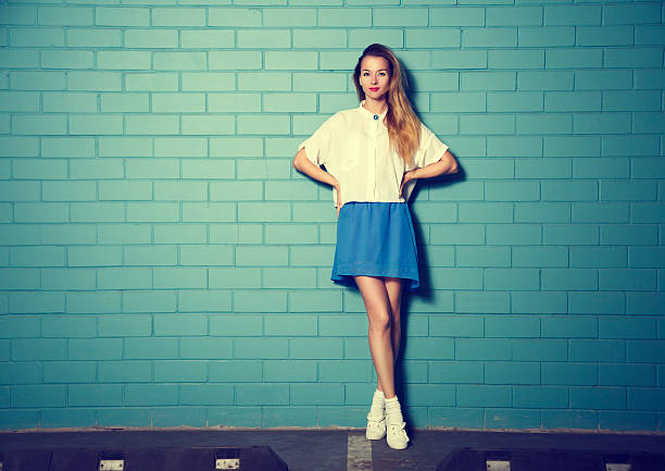 Trendy Hipster Girl at the Turquoise Brick Wall stock photo