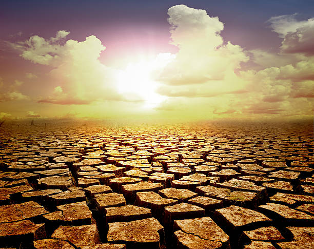 istock orange cloudy sunset over cracked desert 544122118