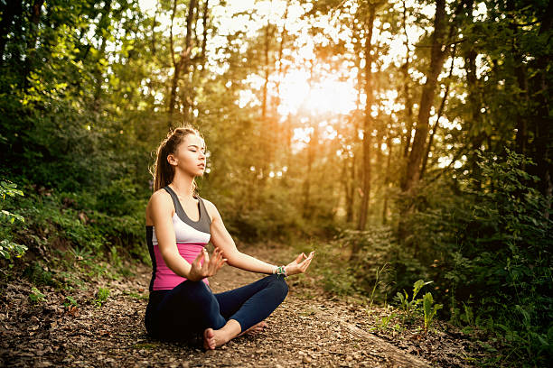 Young woman meditacion in nature and practicing yoga