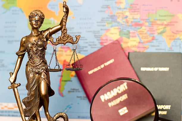 Law concept, statue, magnifying glass, passport and world map. Travel stock photo