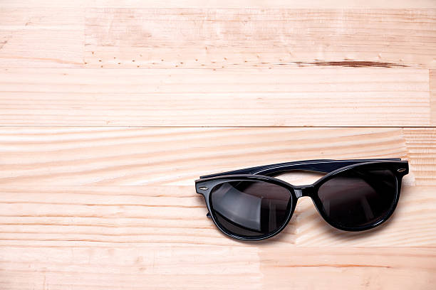 istock Sunglasses in bottom right corner on a wooden background. 544133326
