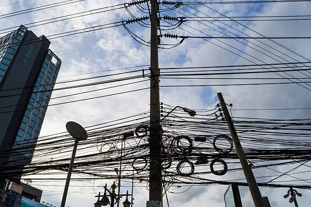беспорядочным электрических кабелей в бангкоке - power line telephone line editorial asia стоковые фото и изображения
