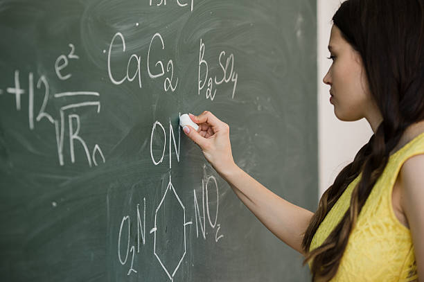 istock pretty young female college student writing on the chalkboard blackboard 544136468
