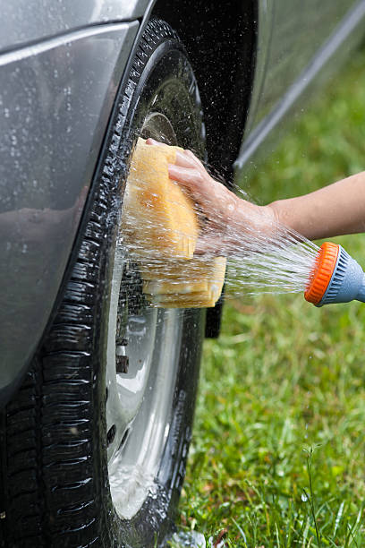 istock hand washing grey car with flowing water and sponge 544137210
