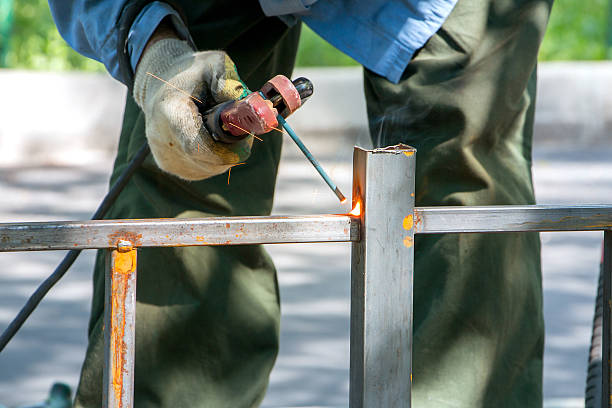 welder makes metal fence welder welds metal fence and sparks fly in different directions automatic welding torch stock pictures, royalty-free photos & images