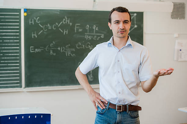 istock Young teacher near chalkboard in school classroom talking to class 544138518