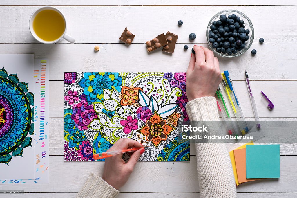 Flat lay, female coloring adult coloring books, stress relieving trend Flat lay, female coloring adult coloring books, new stress relieving trend Adult Stock Photo