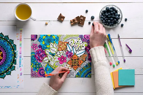 Photo of Flat lay, female coloring adult coloring books, stress relieving trend