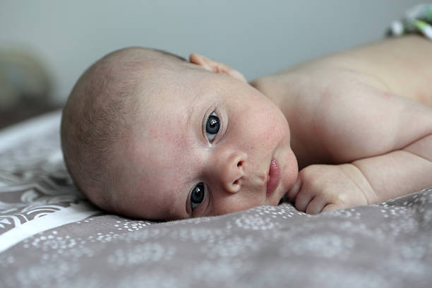 istock Pensive newborn baby on a bed 544314176