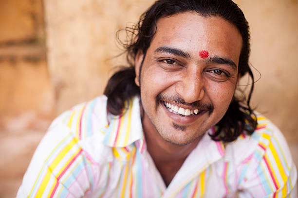 Rajasthan, India - February 25, 2006: Old peasant with turban and mustache greets with the traditional namaste in the interior of Fort Nayla, near Jaipur