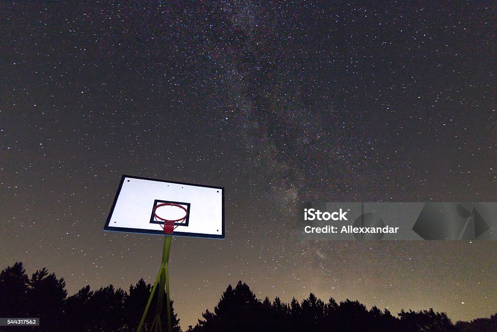 Basketball hoop and board under starry night. Milky way galaxy Basketball hoop and board under starry night. Moving Up Stock Photo