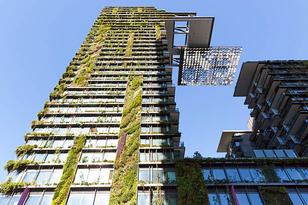 Vertical garden, green wall and heliostat on high rise building Low angle view of vertical garden-BioWall or living wall is a wall covered with living plants on high rise residential building with heliostat of motorised mirrors, Sydney Australia, full frame horizontal composition heliostat photos stock pictures, royalty-free photos & images