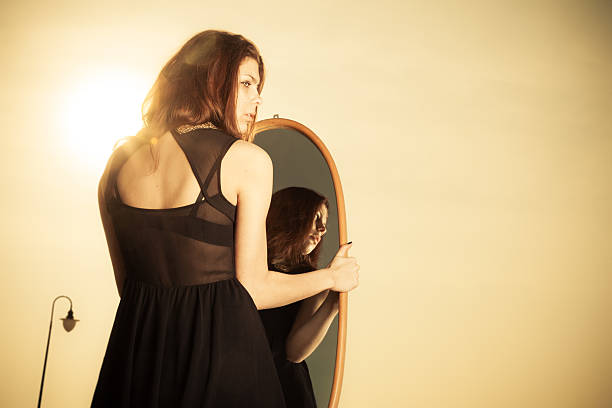 istock thoughtful woman looks at reflection in mirror 544320918