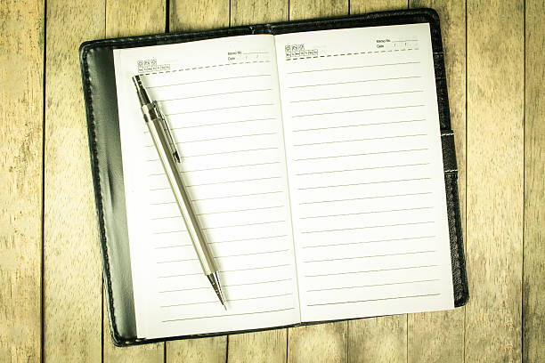 istock notebook and pen on wood desk, vintage toned 544321478