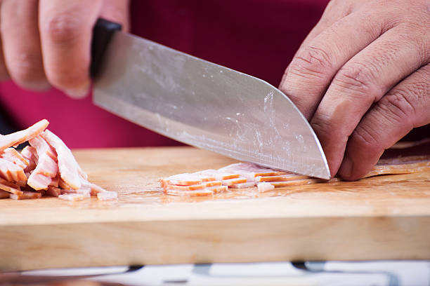 istock Closed up Chef cutting bacon with knife before cooking 544323894