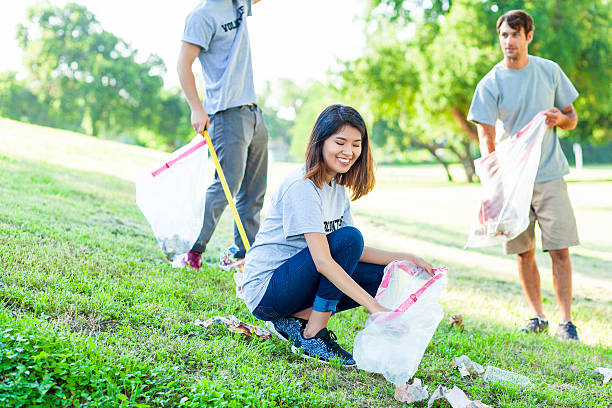 istock Friendly diverse volunteers pick up trash in local park 544326396