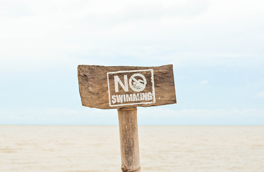 Photograph image of a wooden no swimming sign.