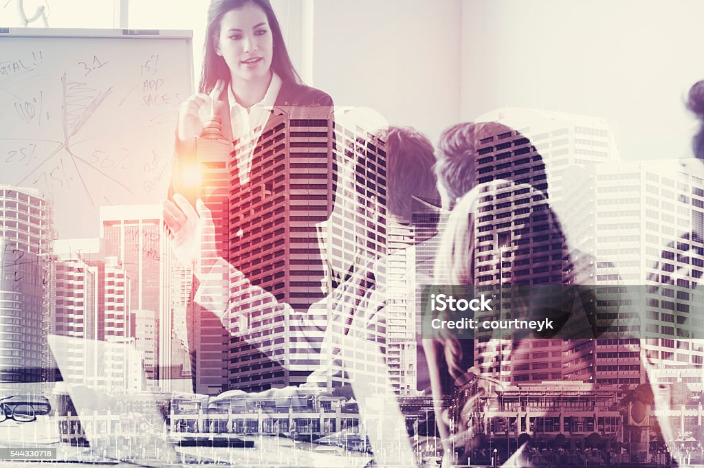 Group of business people in a presentation. Group of business people in a presentation. This is a montage which has a city scape overlaid. Brainstorming and teamwork concept. Multiple Exposure Stock Photo