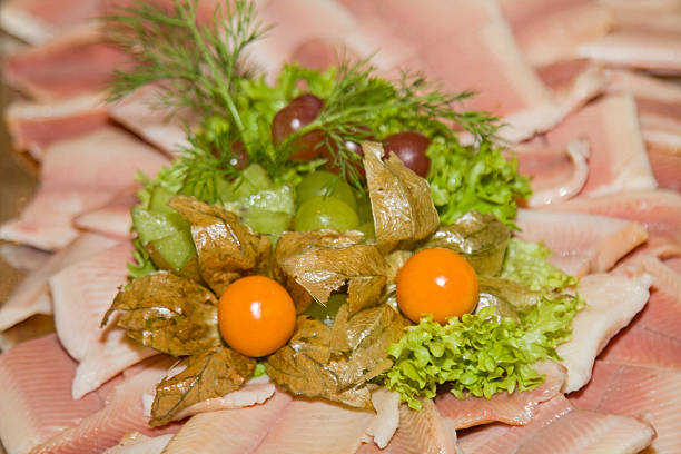 Platter with smoked trout fillet garnished with salad and Physialis