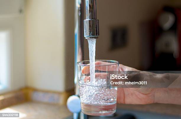 Woman Filling A Glass Of Water From A Tap Stock Photo - Download Image Now - Water, Faucet, Drinking Glass