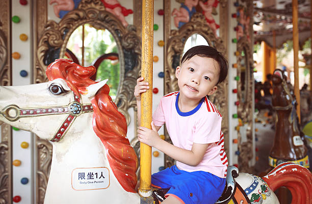 istock Child having fun riding on a colorful carnival carousel 544336960