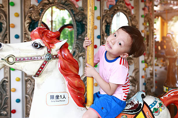 istock Child having fun riding on a colorful carnival carousel 544337110