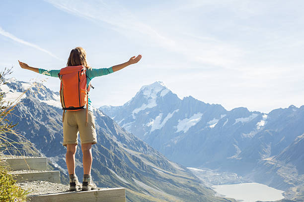 istock Cheering hiker on mountain top celebrates achievement 544337258