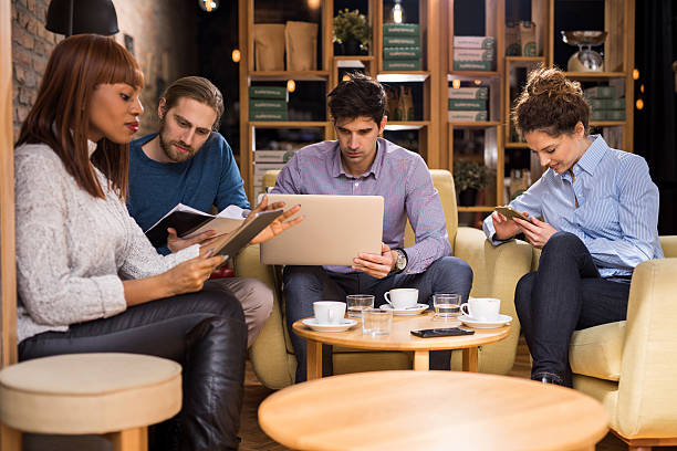 istock Multi-tasking group of business people working in a cafe. 544339026