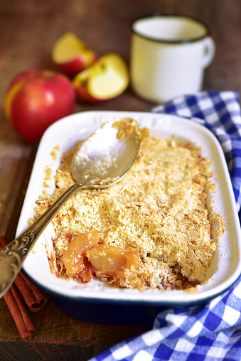 Apple crumble - traditional english dessert on a rustic wooden background.