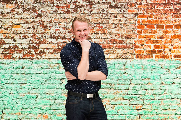 istock Smiling casual man in front of brick wall 544343724
