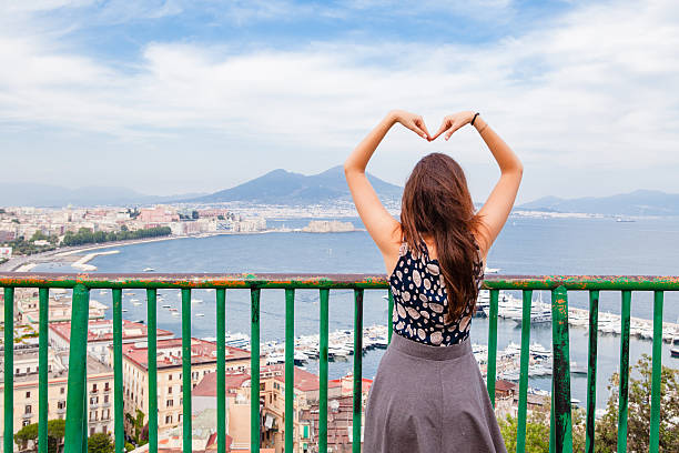 Bellissima ragazza fare a forma di cuore su sfondo di città di Napoli - foto stock